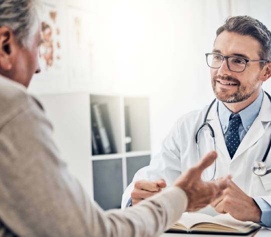 Clinic, senior patient and medical professional at desk with support, trust and healthcare at checkup