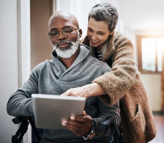 Couple, wheelchair and elderly on tablet in home, streaming entertainment and relax together