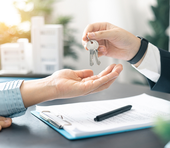 Real estate agent handed over the key to new home, marking a successful investment in business of property