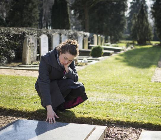 Woman sitting at grave