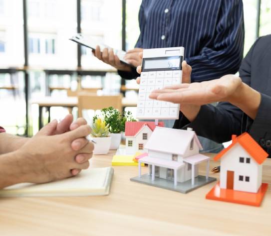 A home salesperson is making a sale to potential buyers by showing them a model home and making an offer to buyers before they make a decision. 